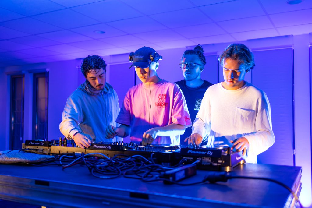 Quatre DJ étudiants aux platines sous les éclairages de scène lors de l'inauguration du campus ESSCA d'Aix-en-Provence, reportage Florent Ruyssen
