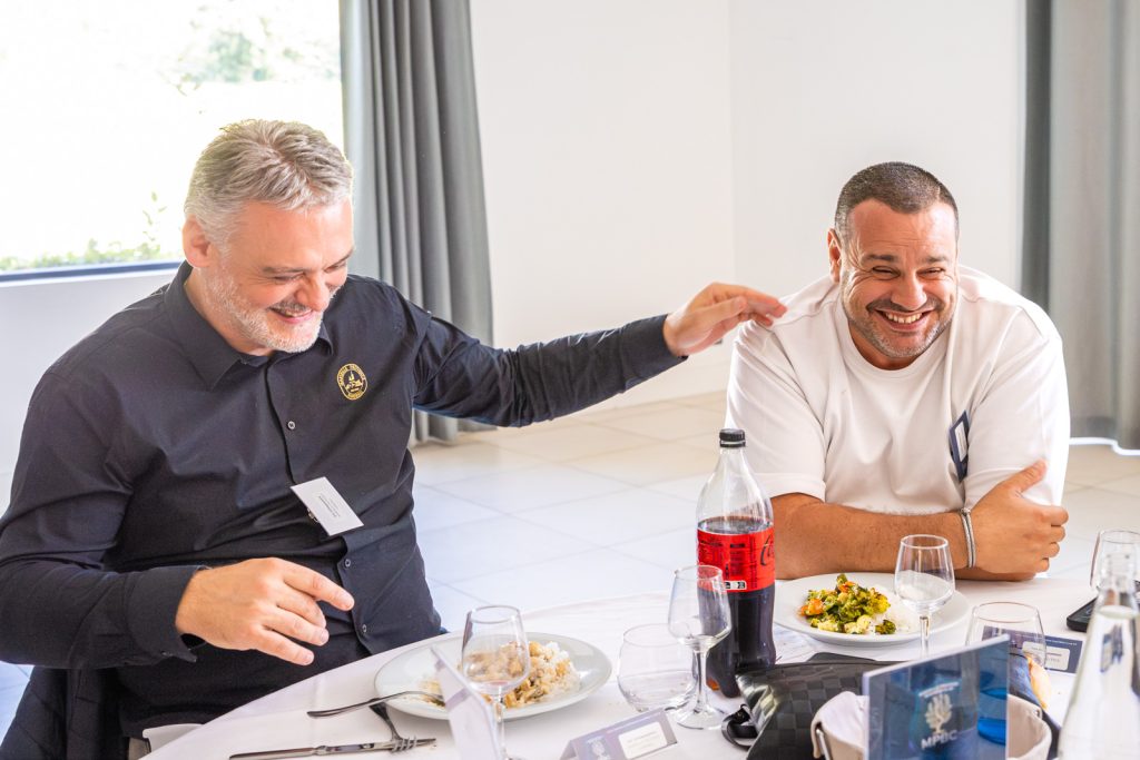 Deux participants d'un déjeuner de club d'affaires en pleine conversation, reportage de Florent Ruyssen
